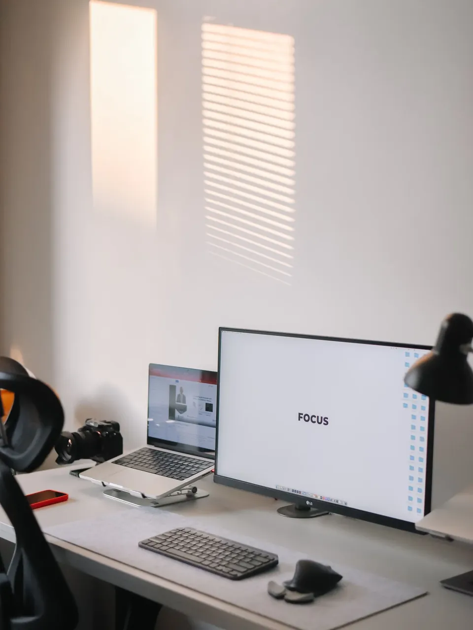 Laptop and monitor on a desk in a bright workspace