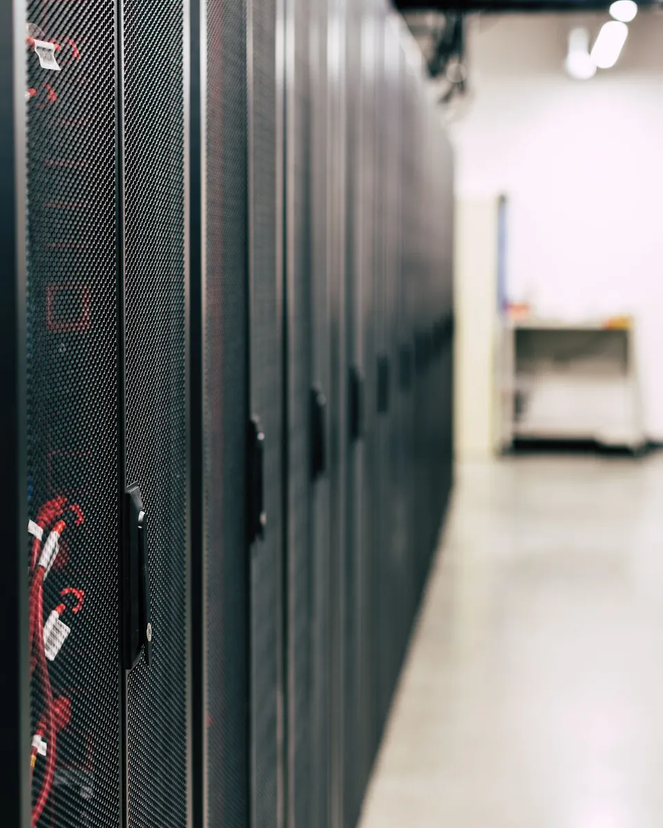Rows of server cabinets in a brightly lit data centre