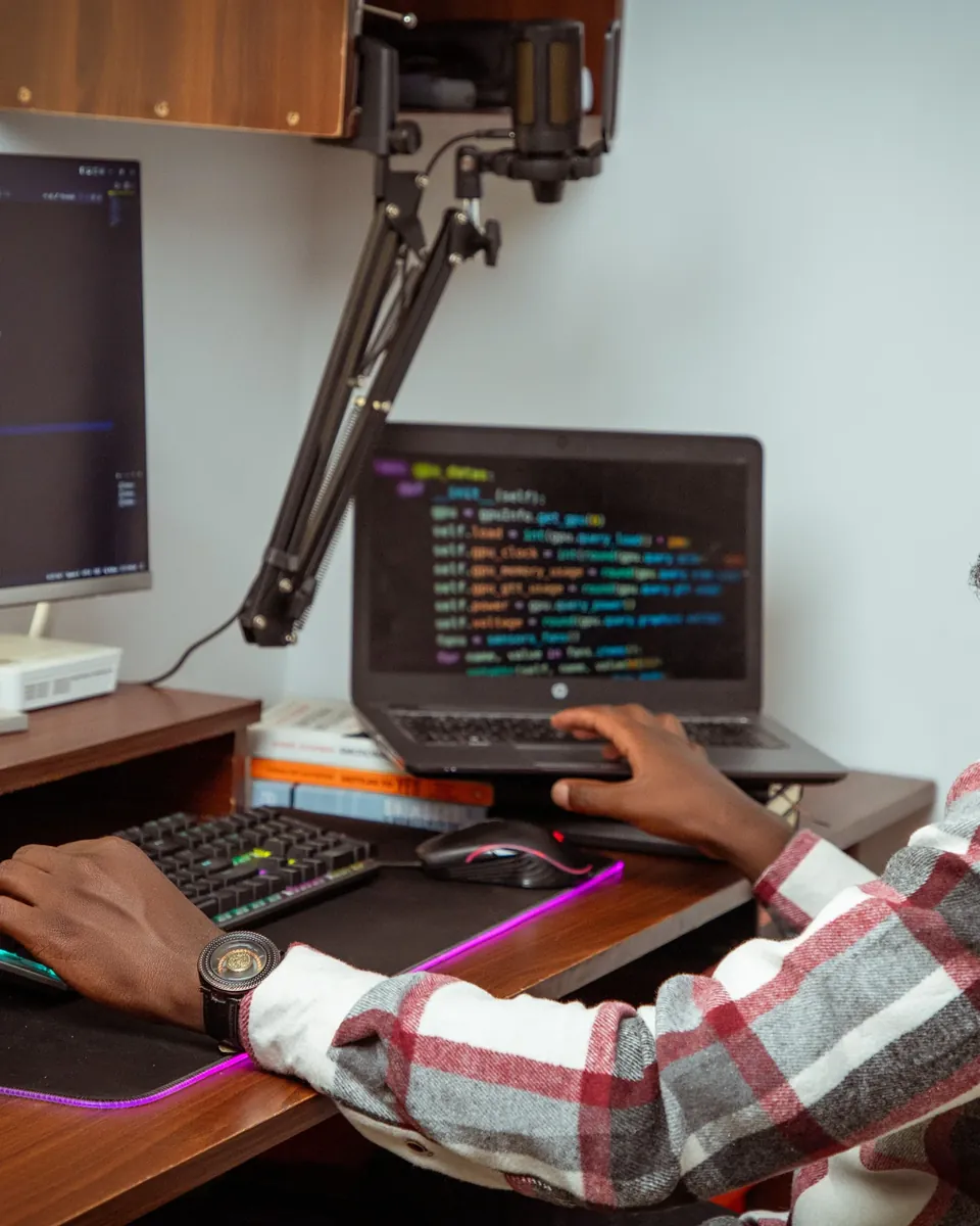 Professional writing code on a laptop at a desk