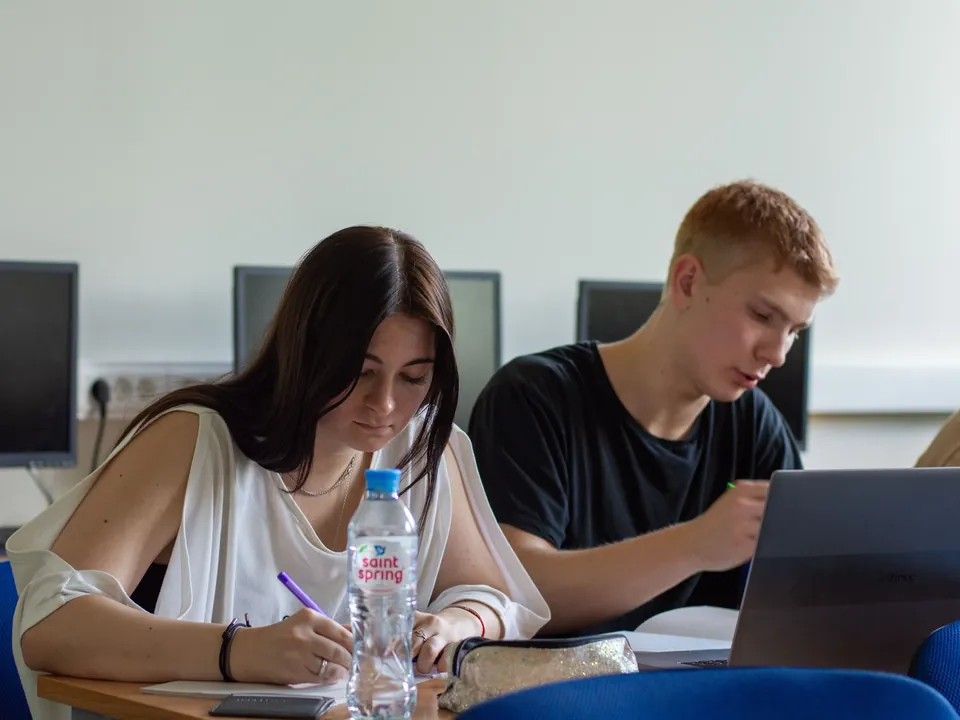 Students working with laptops and computers in a university lab