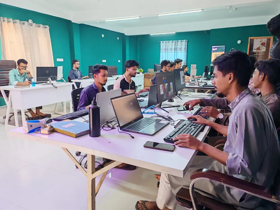 Team working on laptops and monitors in a bright shared office