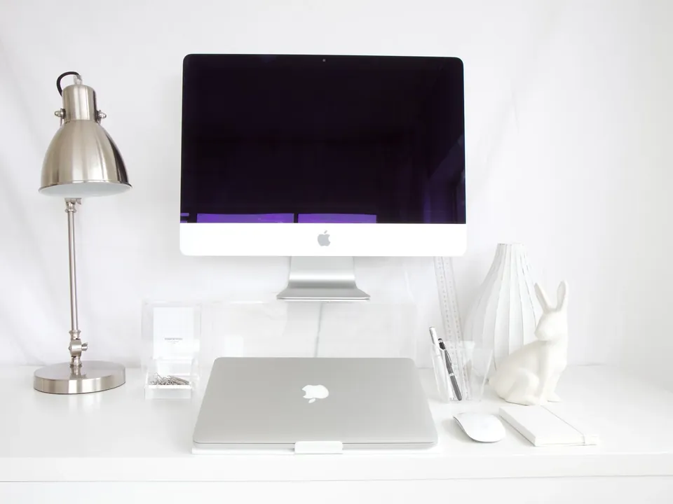 All-in-one desktop computer and laptop on a white desk