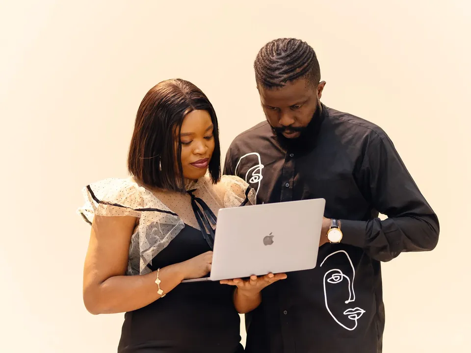 Two professionals reviewing work on a laptop