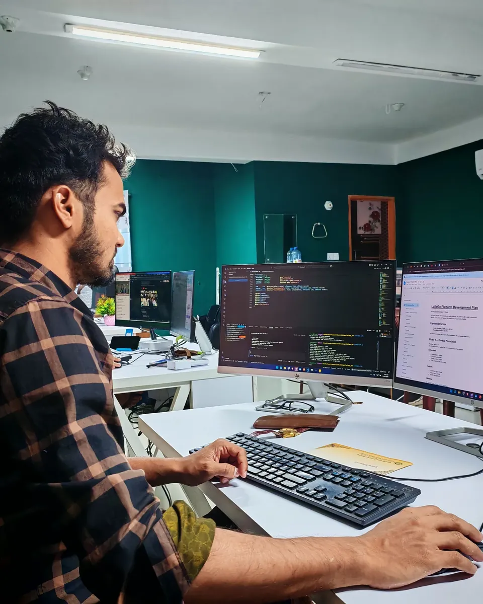 Software developer working across two monitors in an office